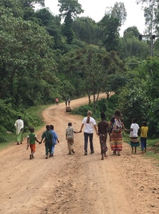 Sarah and Rachel walking hand-in-hand with some of the village children